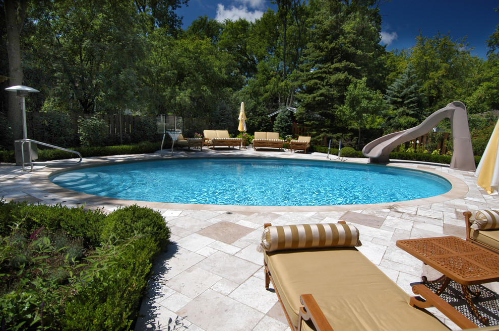 Diseño de piscina con tobogán natural moderna de tamaño medio a medida en patio trasero con adoquines de piedra natural