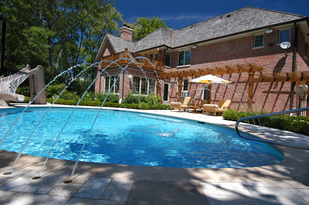 Immagine di una piscina naturale moderna personalizzata di medie dimensioni e dietro casa con un acquascivolo e pavimentazioni in pietra naturale