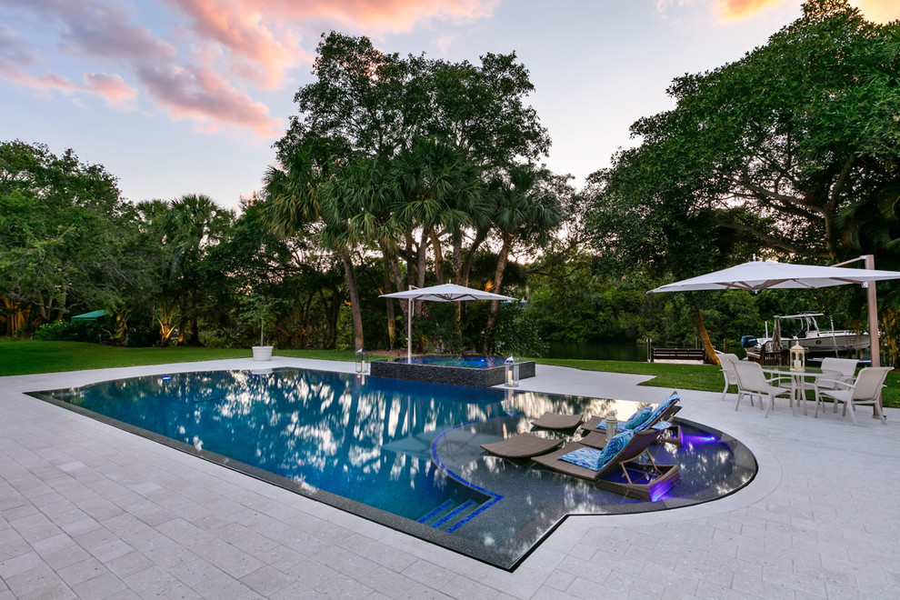 Foto de piscinas y jacuzzis infinitos contemporáneos de tamaño medio a medida en patio trasero con entablado