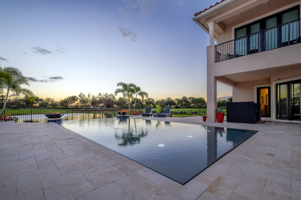 Idee per una piscina a sfioro infinito contemporanea rettangolare di medie dimensioni e dietro casa con fontane e pavimentazioni in pietra naturale