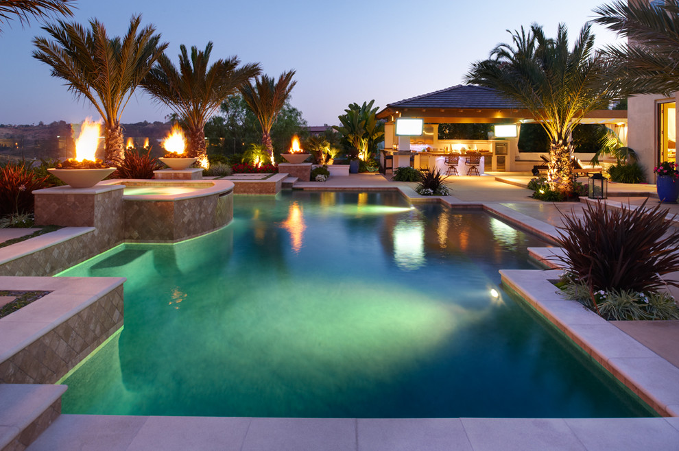 Bild på en mycket stor tropisk anpassad pool på baksidan av huset, med marksten i betong och spabad