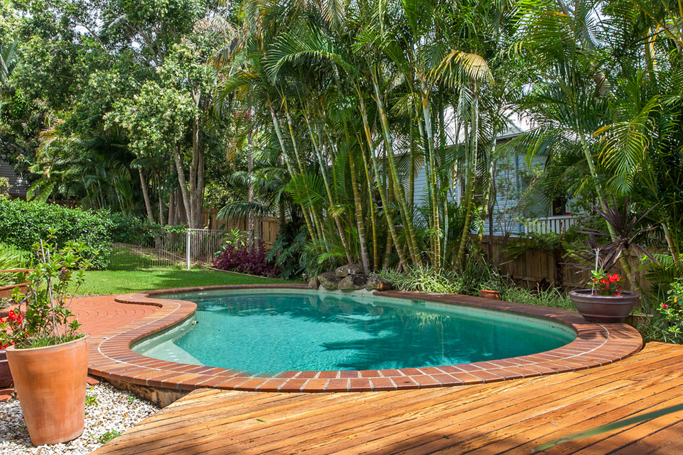 Пример оригинального дизайна: бассейн среднего размера, в форме фасоли на переднем дворе в современном стиле с мощением клинкерной брусчаткой