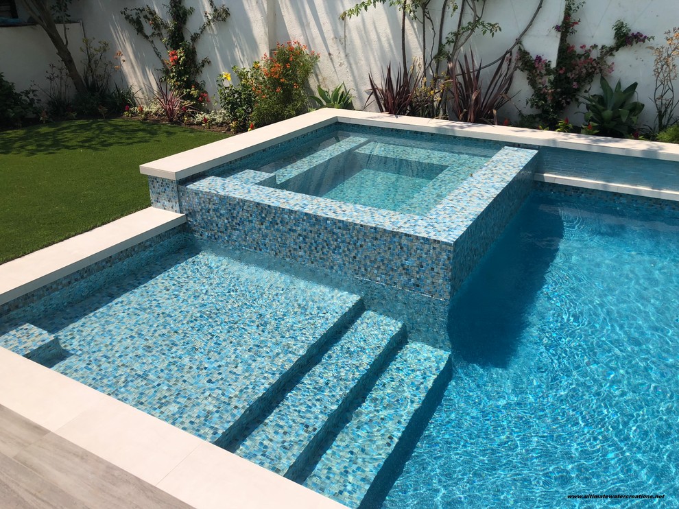 Diseño de piscina contemporánea de tamaño medio rectangular en patio trasero con suelo de baldosas