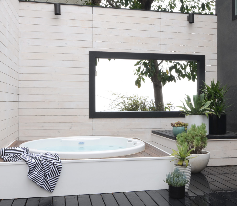 Exemple d'une petite piscine hors-sol et arrière tendance ronde avec un bain bouillonnant et une terrasse en bois.