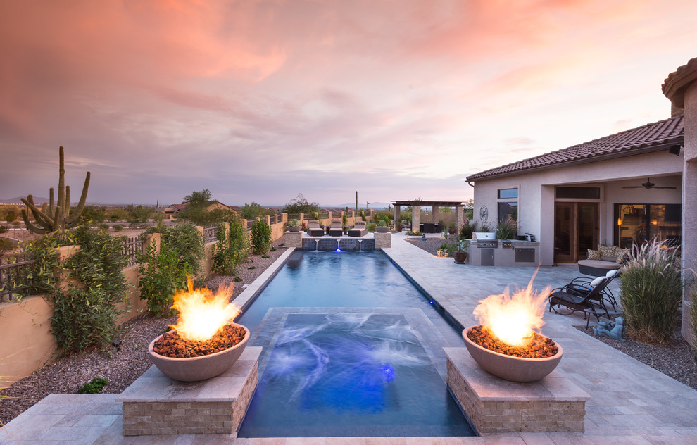 Example of a large trendy backyard rectangular infinity pool fountain design in Phoenix
