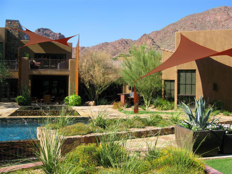 Foto de piscinas y jacuzzis infinitos contemporáneos grandes a medida en patio trasero con adoquines de piedra natural