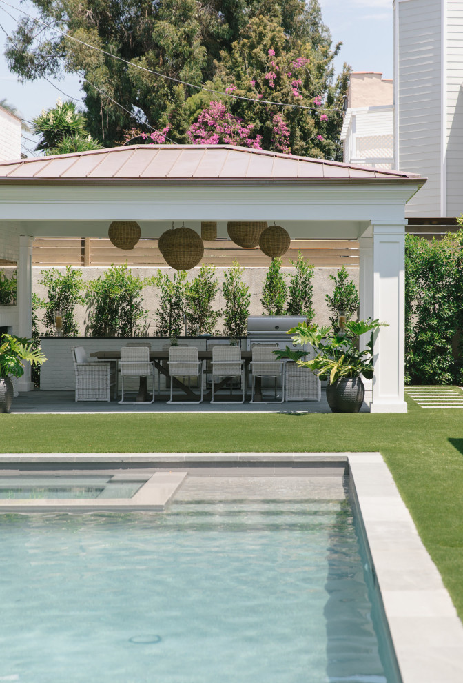Ejemplo de piscina alargada costera de tamaño medio rectangular en patio trasero con adoquines de hormigón