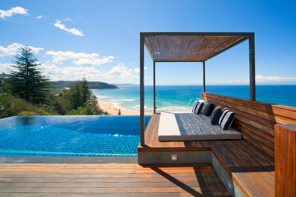 Idée de décoration pour une petite piscine à débordement design avec une terrasse en bois.