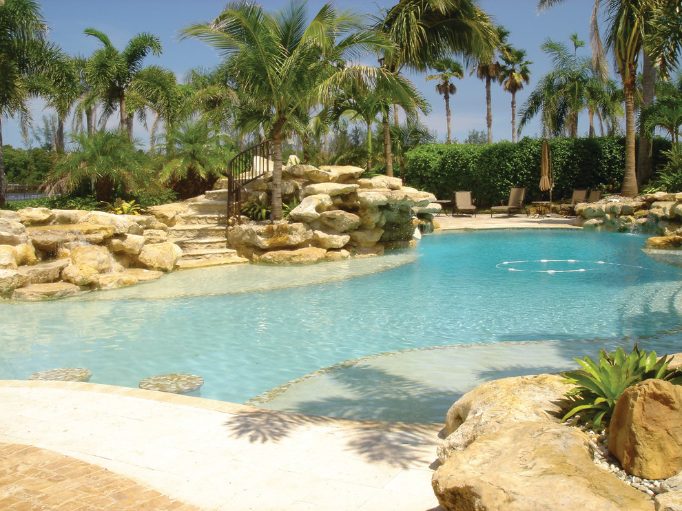 Pool - tropical backyard stone and custom-shaped pool idea in Miami