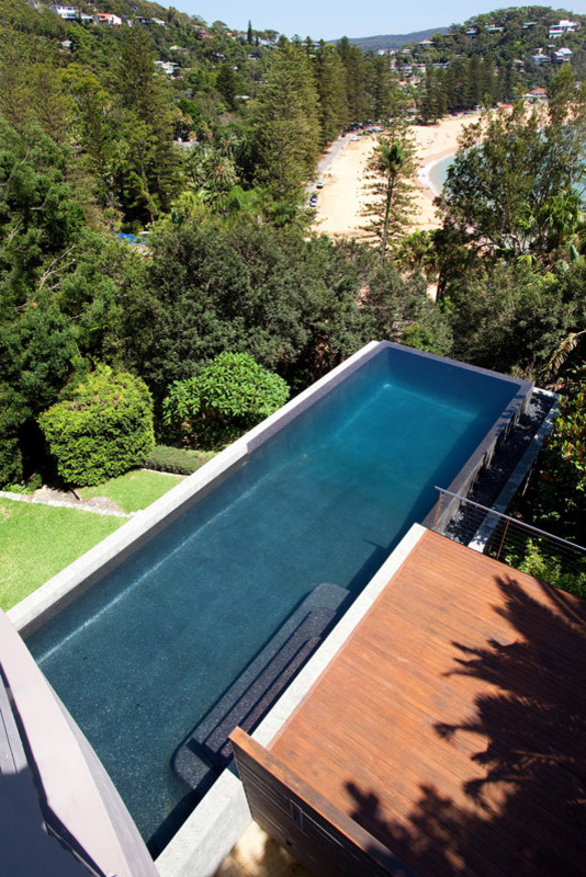 Immagine di un'ampia piscina monocorsia minimalista personalizzata dietro casa con pedane
