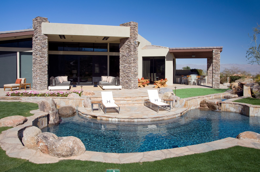 Imagen de piscina con fuente moderna de tamaño medio a medida en patio trasero con adoquines de piedra natural