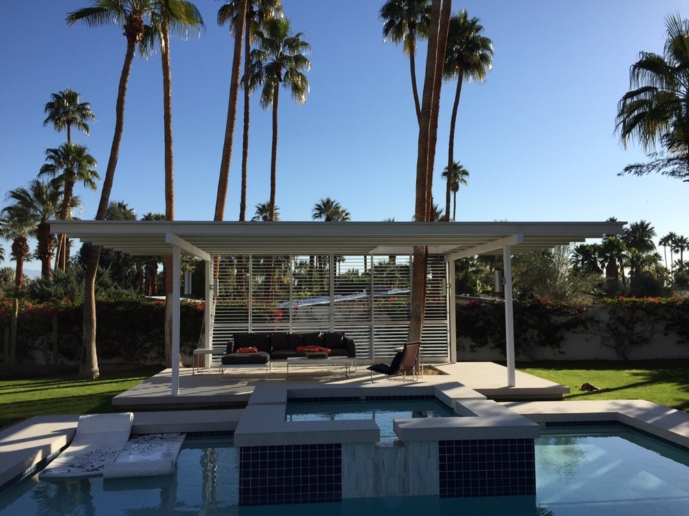 Foto de casa de la piscina y piscina moderna de tamaño medio en patio trasero con losas de hormigón