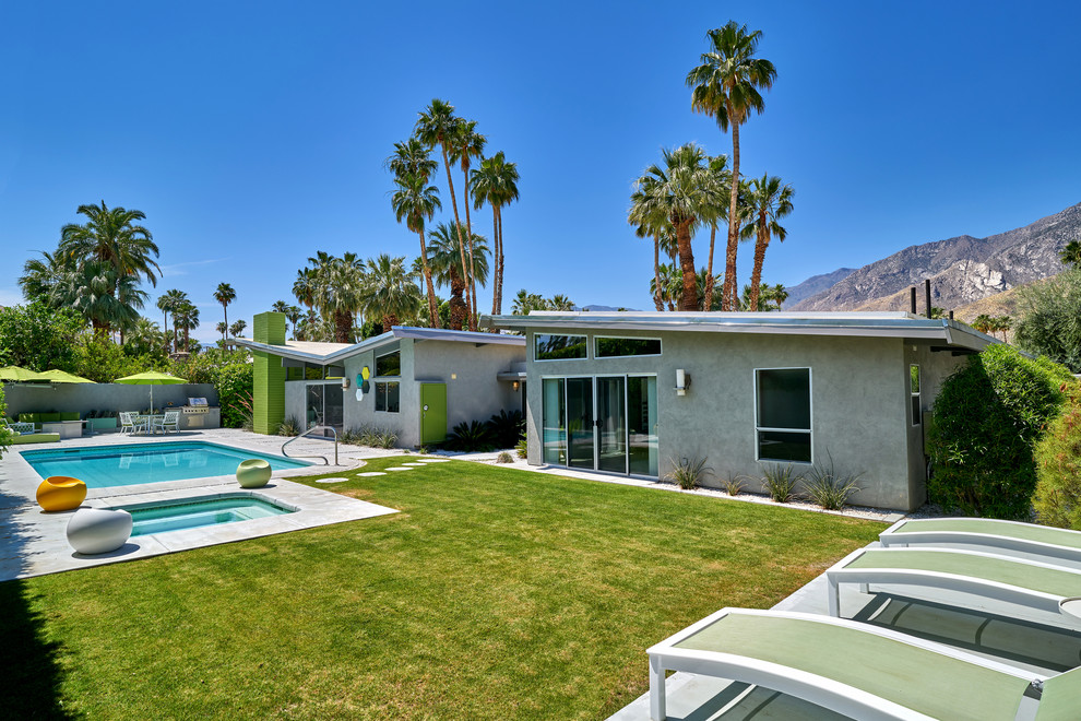 Photo of a large midcentury back rectangular natural swimming pool in Other.