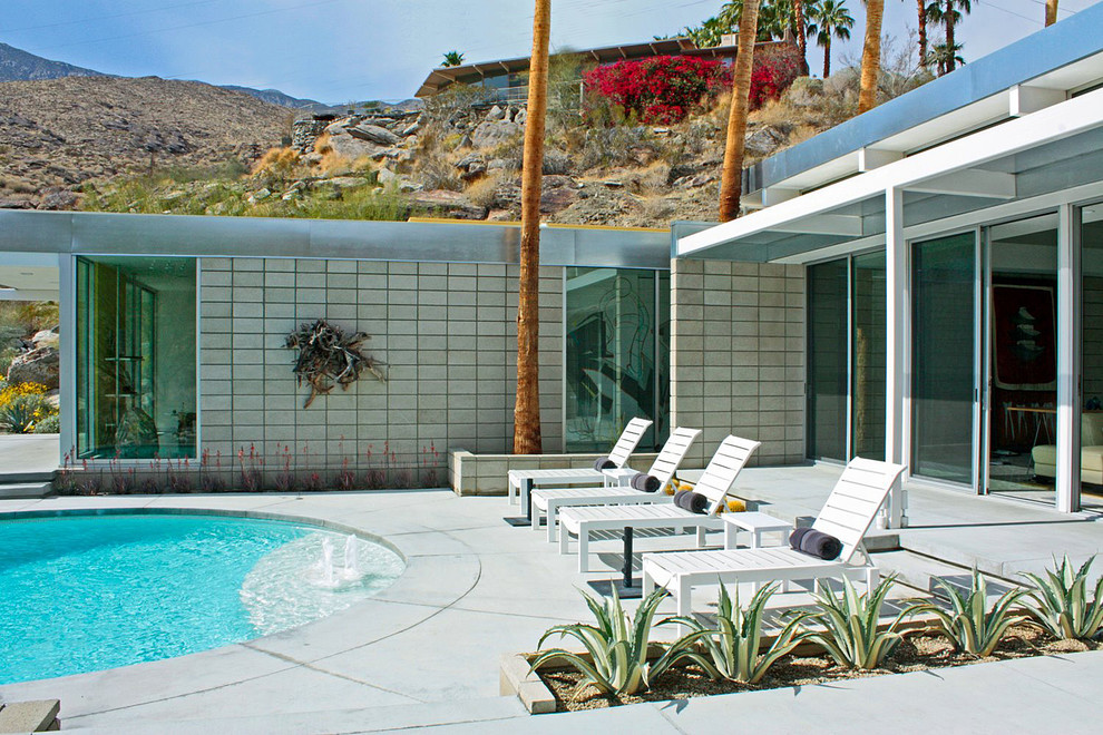 Photo of a medium sized midcentury back round swimming pool in Los Angeles with concrete slabs.