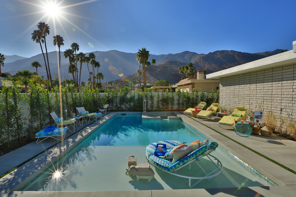 Mittelgroßer Retro Pool hinter dem Haus in rechteckiger Form mit Betonplatten in Los Angeles