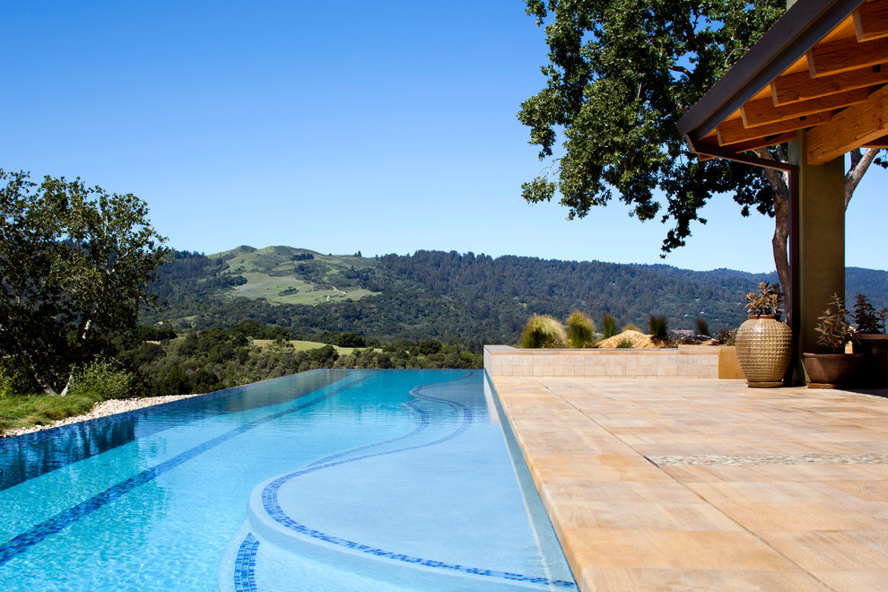 Foto de piscinas y jacuzzis alargados de estilo americano grandes rectangulares en patio trasero con suelo de baldosas