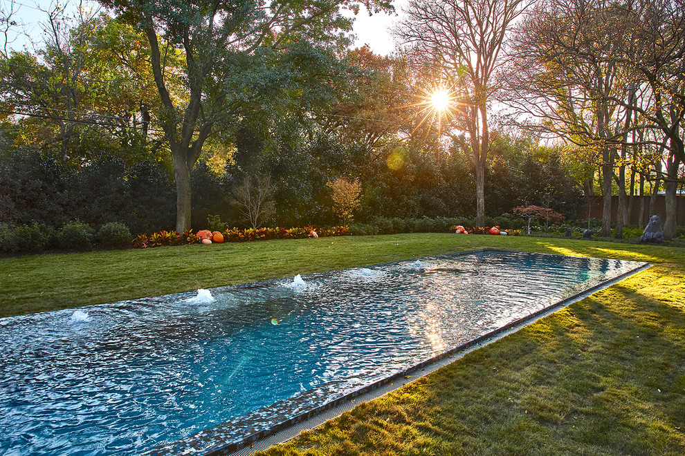 This is an example of an expansive contemporary back rectangular lengths swimming pool in Dallas with a pool house and tiled flooring.