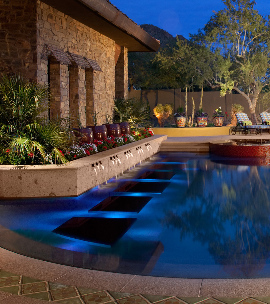 Photo of a custom shaped swimming pool in Phoenix with a water feature.