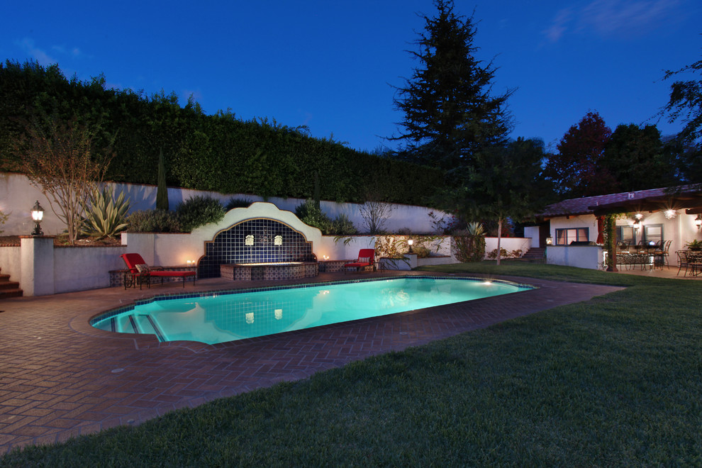 Großes Mediterranes Sportbecken hinter dem Haus in individueller Form mit Wasserspiel und Pflastersteinen in Los Angeles