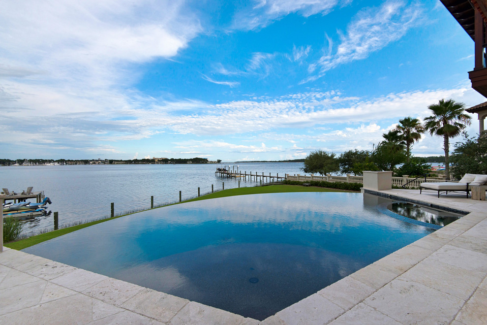 Großer Mediterraner Infinity-Pool hinter dem Haus mit Wasserspiel und Pflastersteinen in Miami