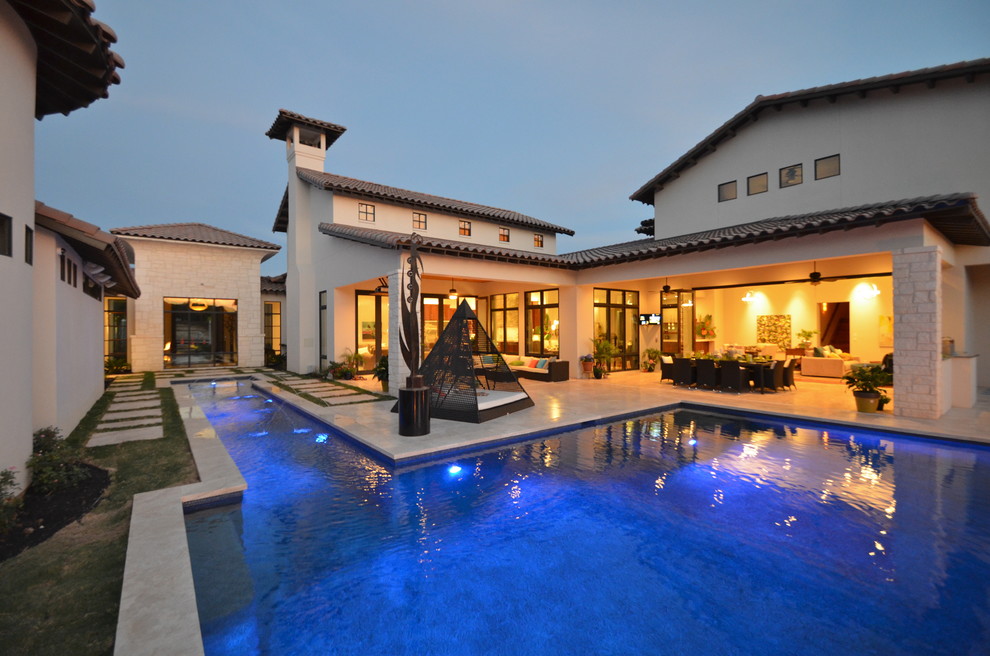 Imagen de piscina alargada contemporánea grande rectangular en patio trasero con adoquines de piedra natural
