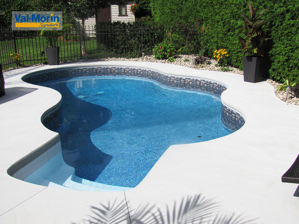Стильный дизайн: бассейн среднего размера, произвольной формы на заднем дворе в морском стиле с покрытием из бетонных плит - последний тренд
