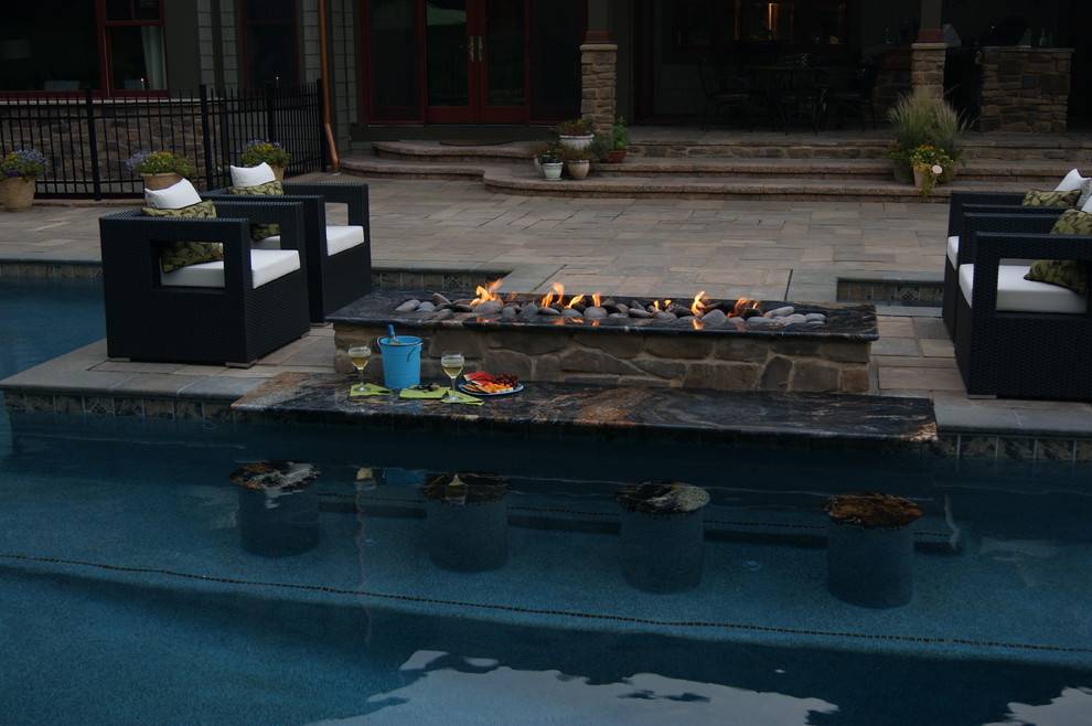 Esempio di un'ampia piscina design personalizzata dietro casa con pavimentazioni in cemento
