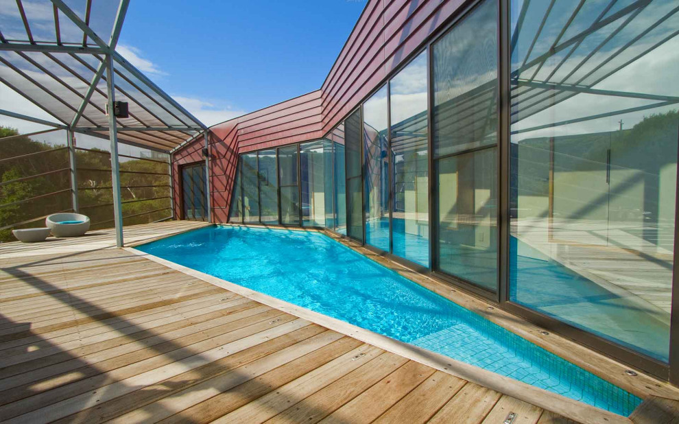 Immagine di una grande piscina fuori terra stile marinaro personalizzata nel cortile laterale con paesaggistica bordo piscina e pedane