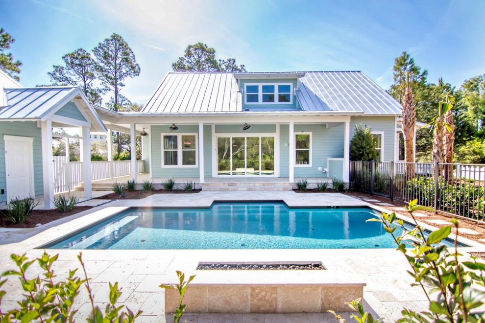 Foto de casa de la piscina y piscina tropical de tamaño medio rectangular en patio trasero con adoquines de hormigón