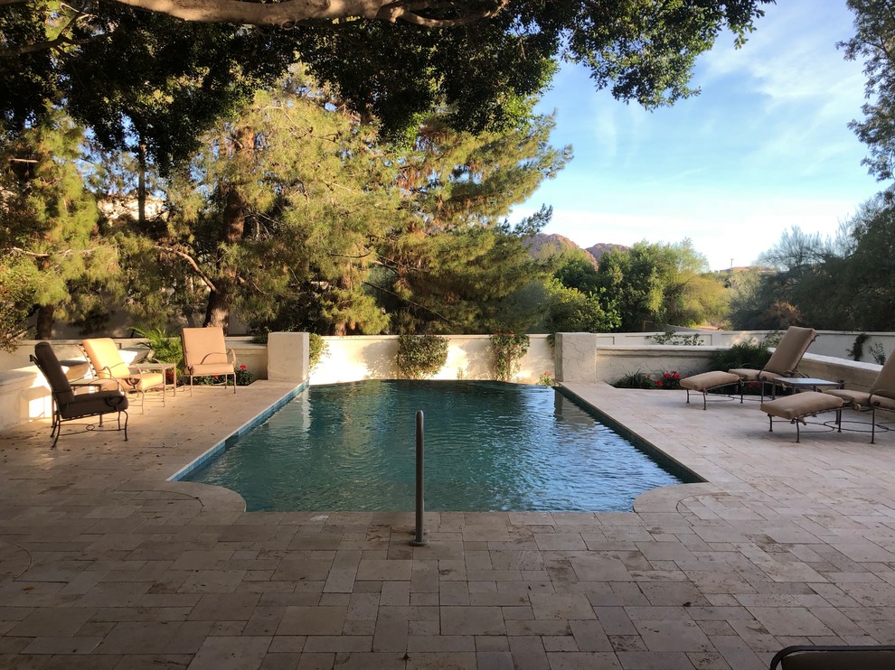 Foto di una piscina a sfioro infinito minimal rettangolare di medie dimensioni e dietro casa con pavimentazioni in pietra naturale