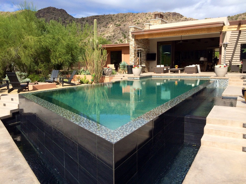 Mittelgroßer Moderner Infinity-Pool hinter dem Haus in rechteckiger Form mit Betonplatten in Phoenix