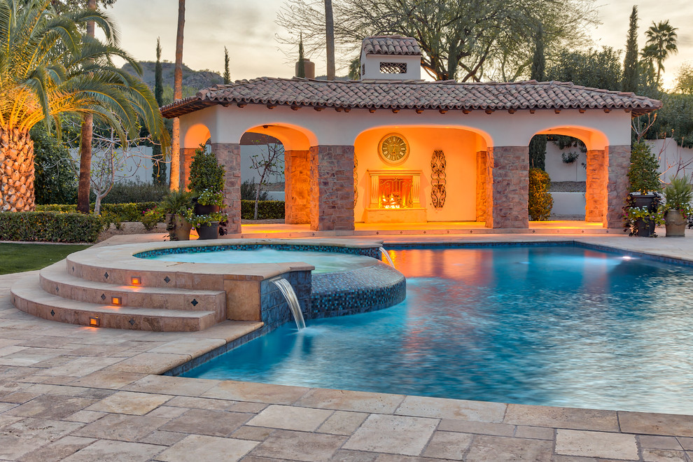 This is an example of a large contemporary back custom shaped swimming pool in Phoenix with concrete paving.