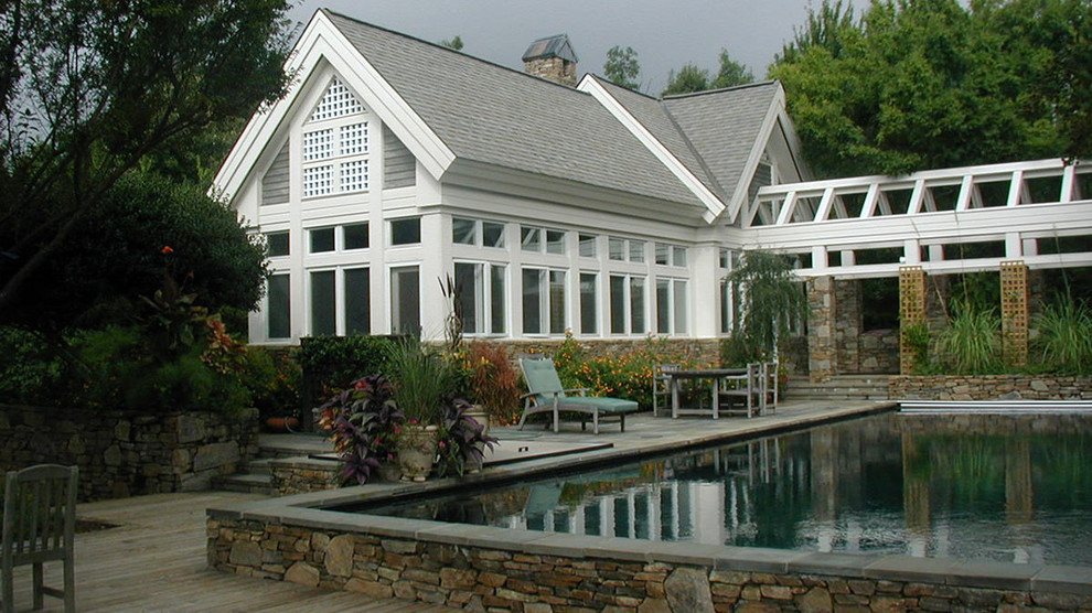 Modelo de piscina elevada tradicional grande rectangular en patio con entablado