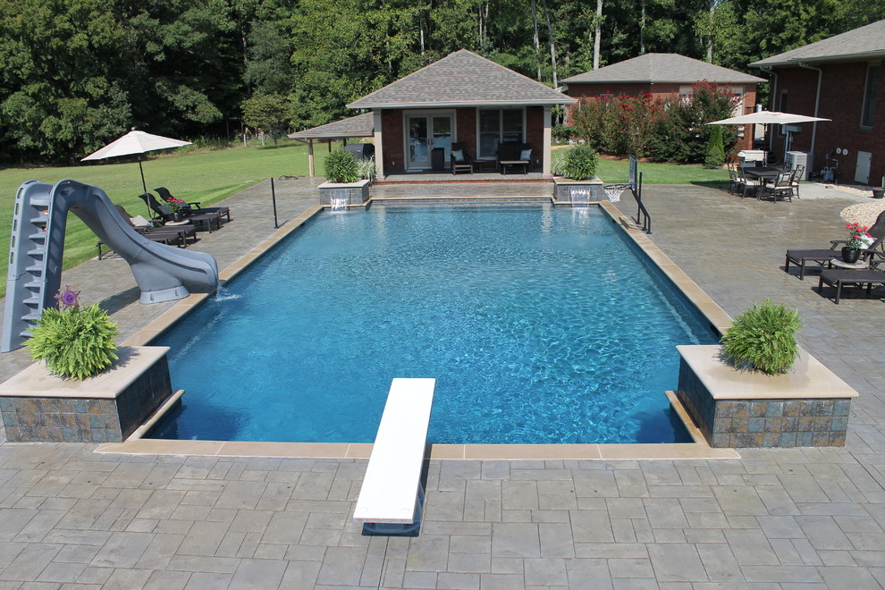 Пример оригинального дизайна: большой прямоугольный бассейн на заднем дворе в современном стиле с фонтаном и мощением тротуарной плиткой