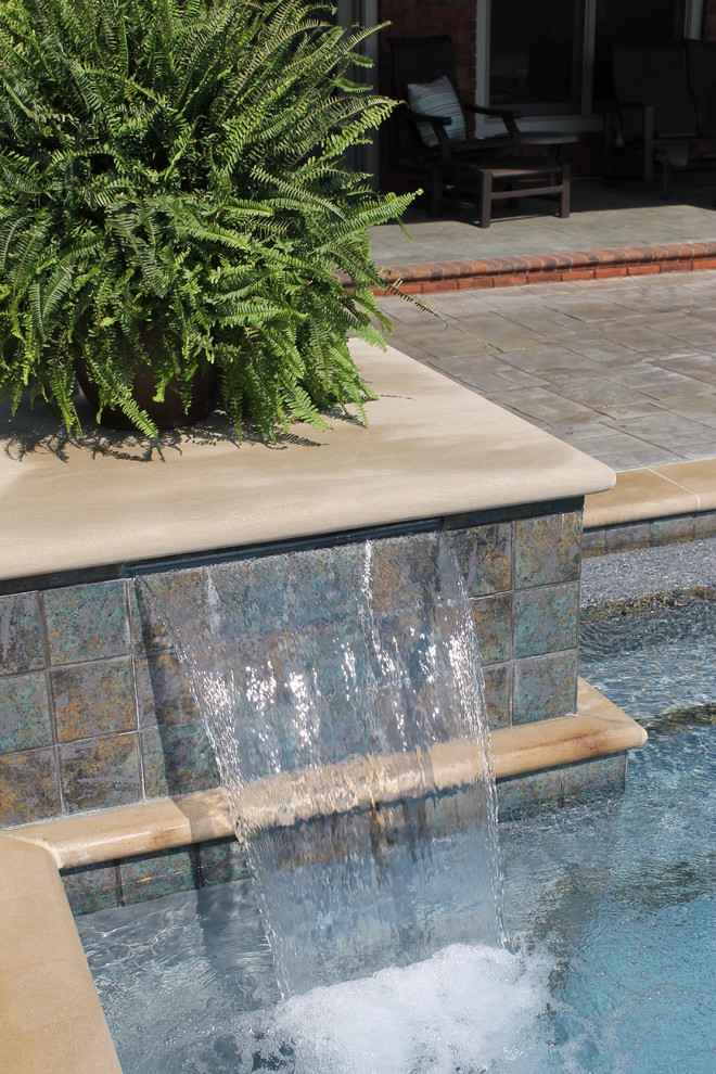 Large trendy backyard concrete paver and rectangular pool fountain photo in Chicago