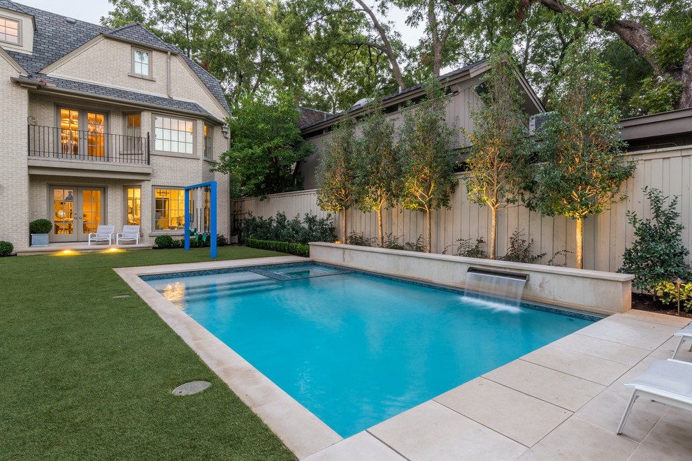 Mid-sized transitional backyard stone and rectangular lap pool fountain photo in Dallas