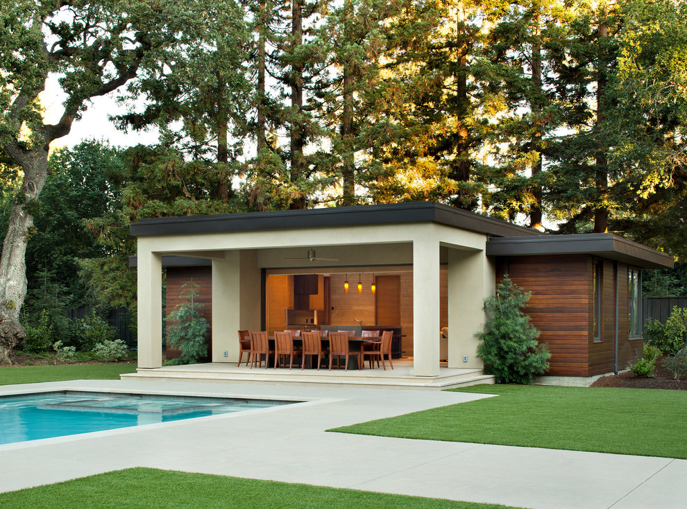 Diseño de casa de la piscina y piscina alargada minimalista grande rectangular en patio trasero con suelo de hormigón estampado