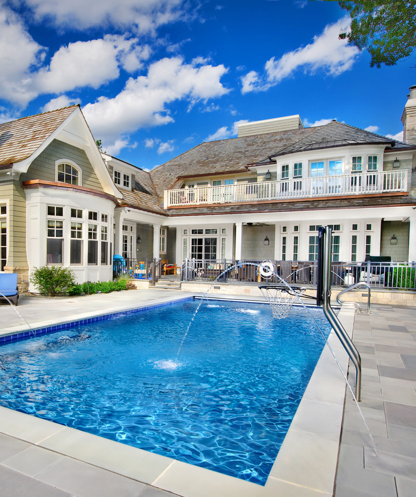 Immagine di una piscina monocorsia chic rettangolare di medie dimensioni e dietro casa con pavimentazioni in pietra naturale e una vasca idromassaggio