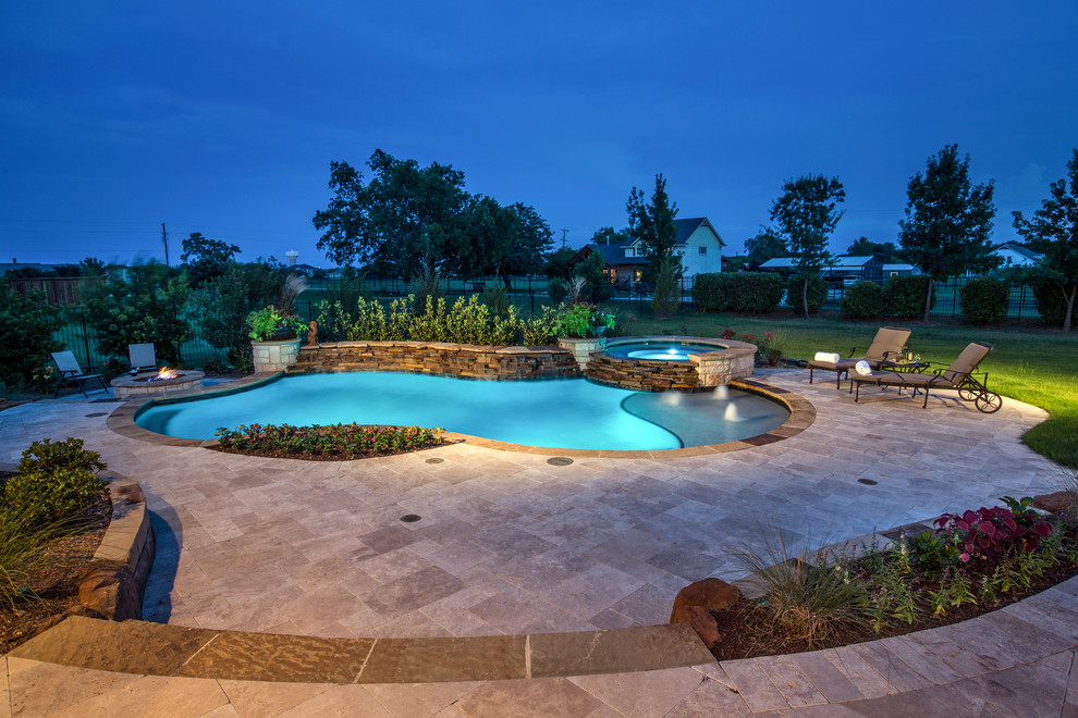 Immagine di una piscina naturale tradizionale personalizzata di medie dimensioni e dietro casa con pavimentazioni in pietra naturale e una vasca idromassaggio
