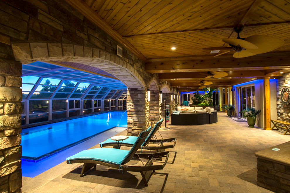 На фото: огромный прямоугольный, спортивный бассейн в доме в стиле фьюжн с мощением тротуарной плиткой