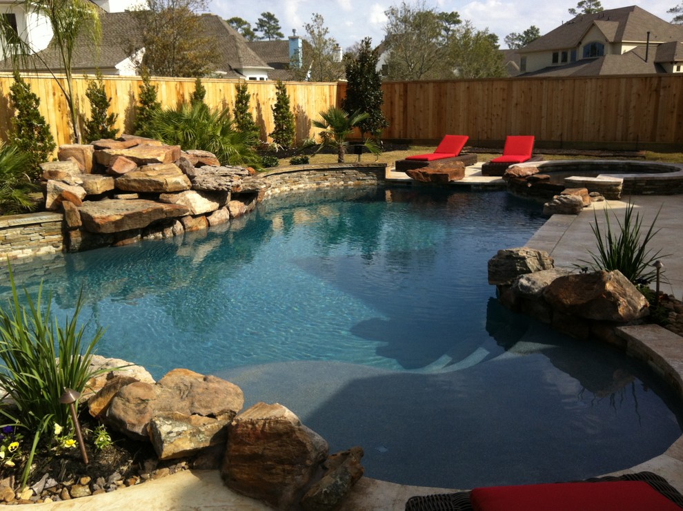 This is an example of a medium sized classic back custom shaped lengths swimming pool in Houston with a water feature and tiled flooring.