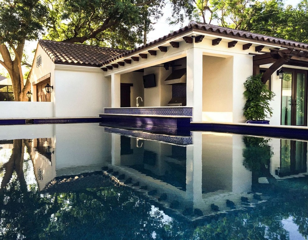 Großer Mediterraner Pool hinter dem Haus in rechteckiger Form mit Betonplatten in Tampa