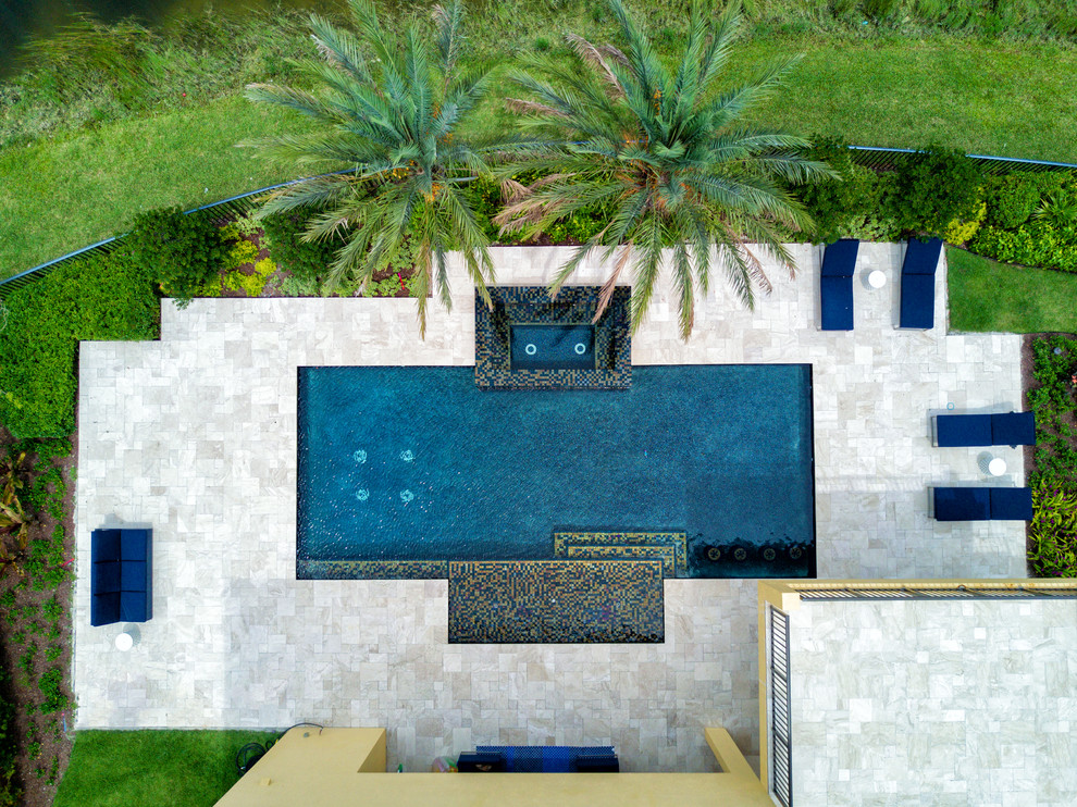 Пример оригинального дизайна: большой круглый бассейн-инфинити на заднем дворе в стиле модернизм с джакузи и покрытием из каменной брусчатки