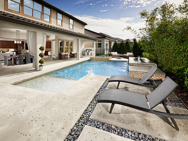 Großer Moderner Pool hinter dem Haus in L-Form mit Betonplatten in Orlando