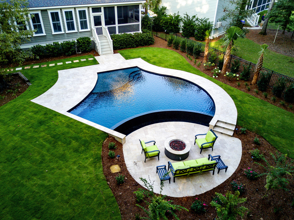 Diseño de piscina infinita tradicional renovada de tamaño medio a medida en patio trasero con adoquines de piedra natural