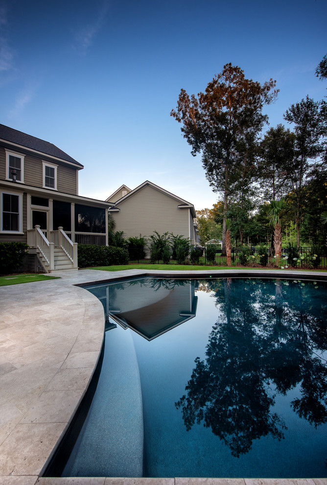 Design ideas for a medium sized traditional back custom shaped infinity swimming pool in Charleston with natural stone paving.