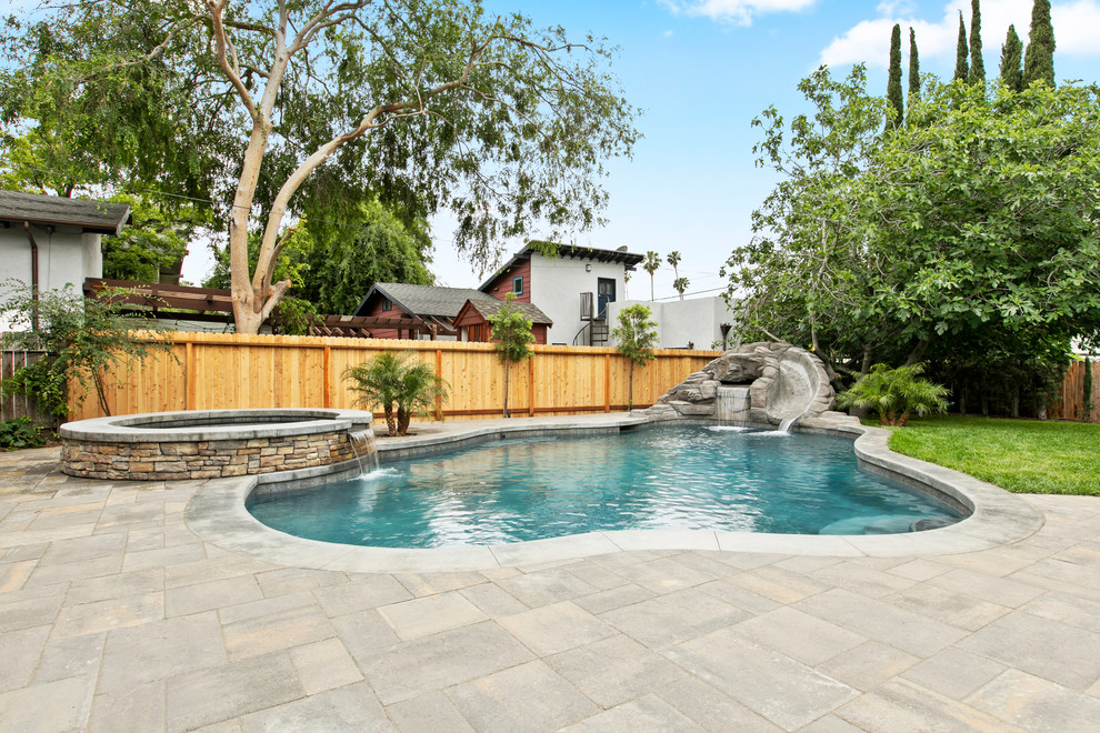 Großer Klassischer Pool hinter dem Haus in individueller Form mit Natursteinplatten und Wasserrutsche in Los Angeles