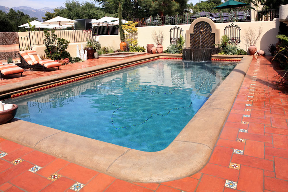 Modelo de piscinas y jacuzzis alargados mediterráneos de tamaño medio rectangulares en patio trasero con adoquines de ladrillo