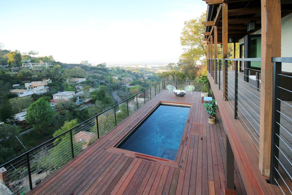 Imagen de piscina alargada ecléctica de tamaño medio rectangular en patio trasero con entablado