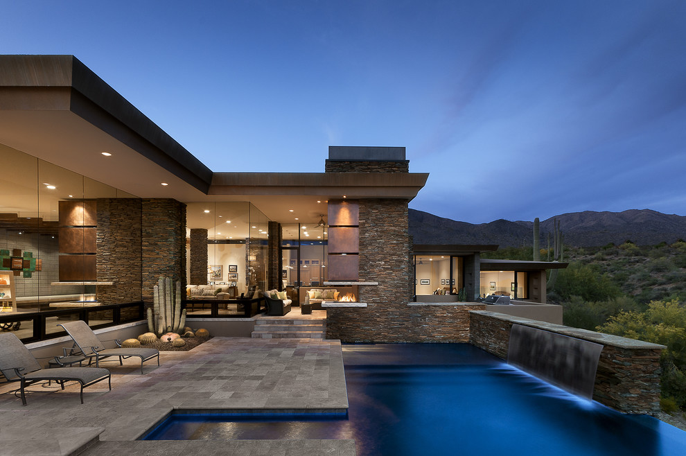 Example of a large southwest backyard custom-shaped and tile infinity pool fountain design in Phoenix